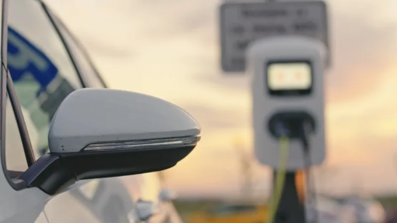 An electric vehicle charging at a station, symbolizing the growing trend of EV ownership