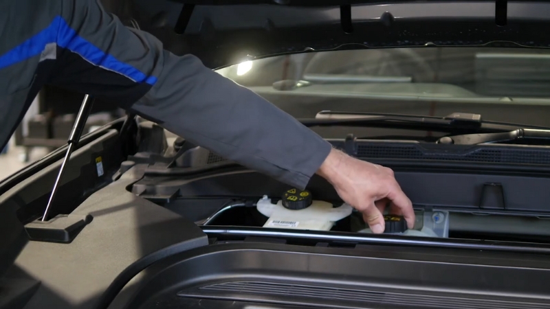 Image of a person checking the fluid reservoir in a Ford Mustang Mach-E