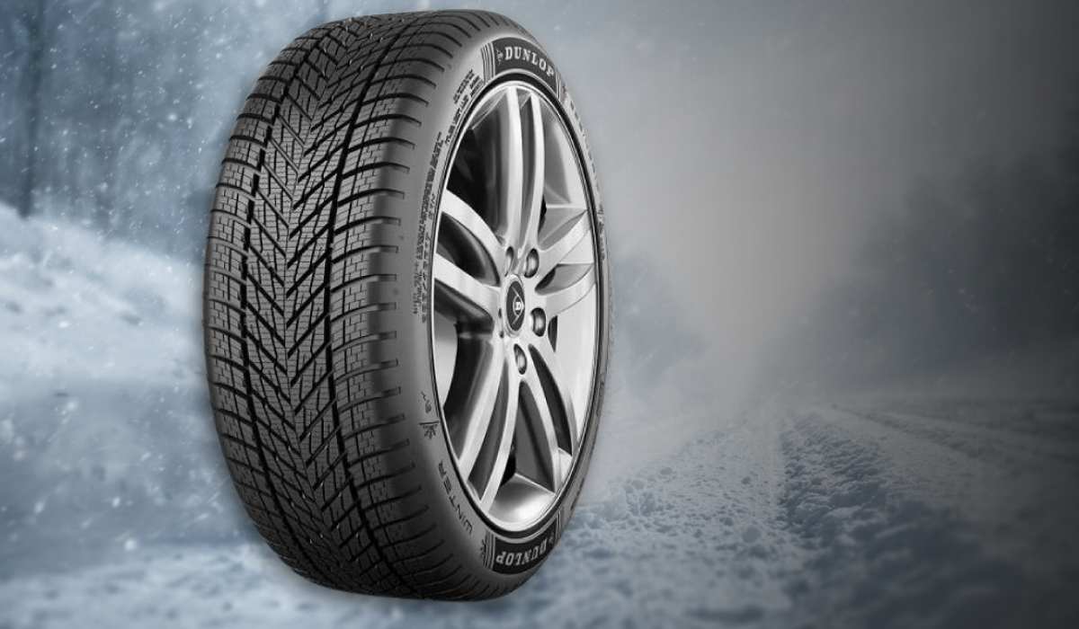 Dunlop winter tire with dense tread pattern on a snowy road background