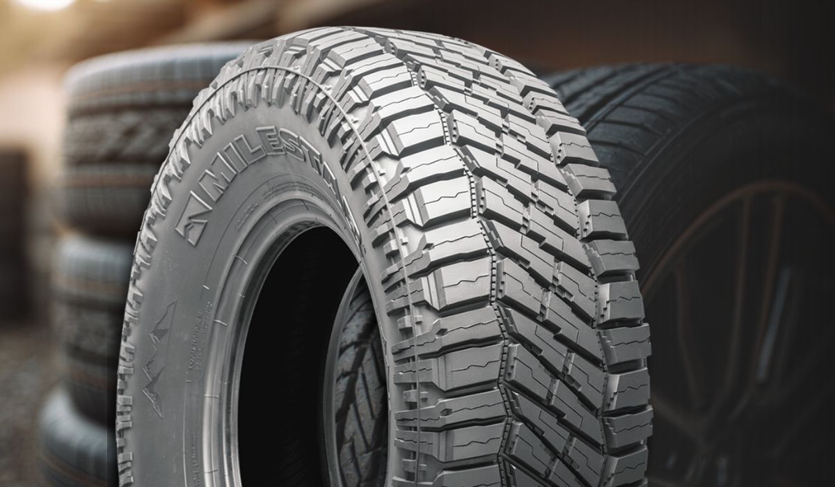 All terrain tire with aggressive tread pattern and stacked tires behind