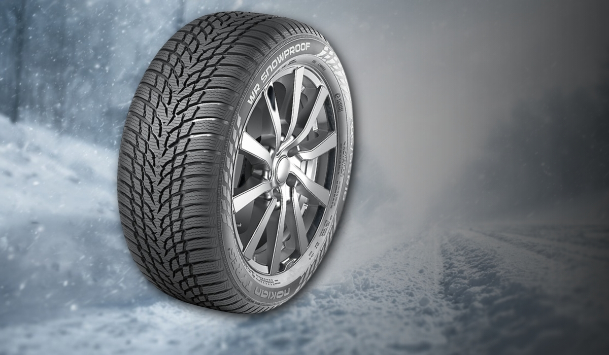 Nokian winter tire with aggressive siped tread on a snowy road background