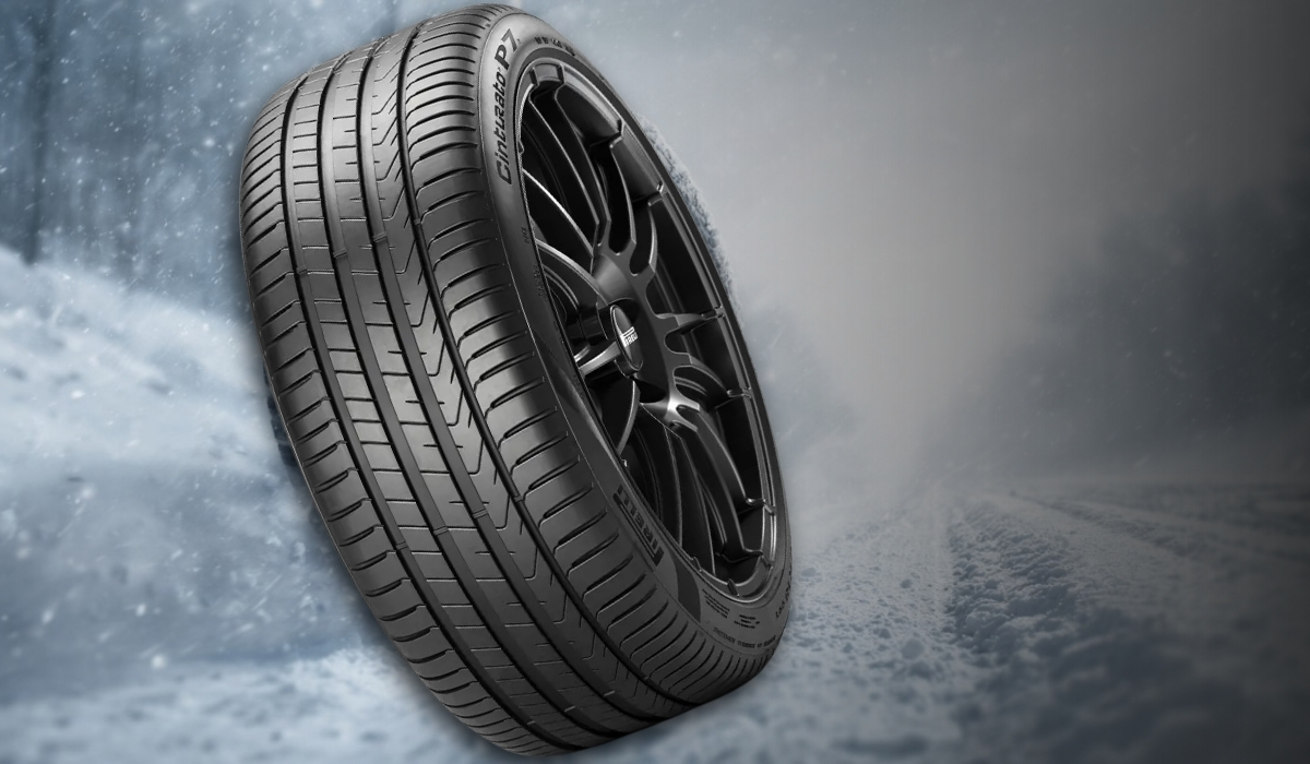 Pirelli winter tire with wide tread grooves on a snowy road background