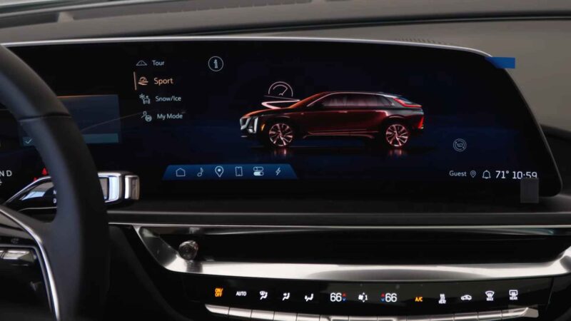 Digital dashboard display inside a Cadillac Lyriq showing driving mode options such as Tour, Sport, Snow/Ice, and My Mode with a vehicle graphic on screen