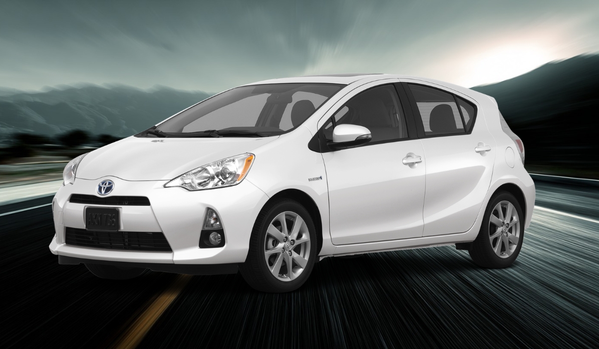 White Toyota Prius c Two driving on a highway with motion blur and mountains in the background
