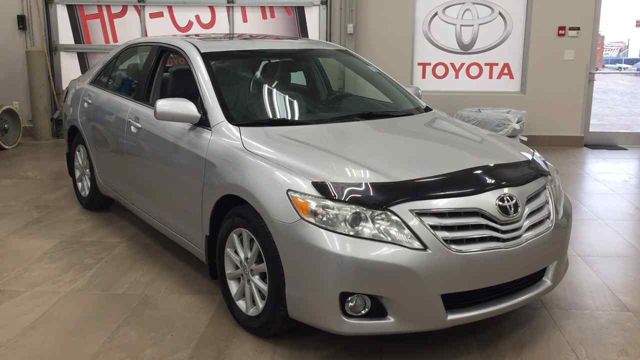 Silver 2010 Toyota Camry displayed inside a dealership showroom