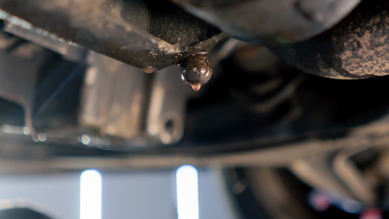 Coolant leak dripping from under the car engine onto the ground