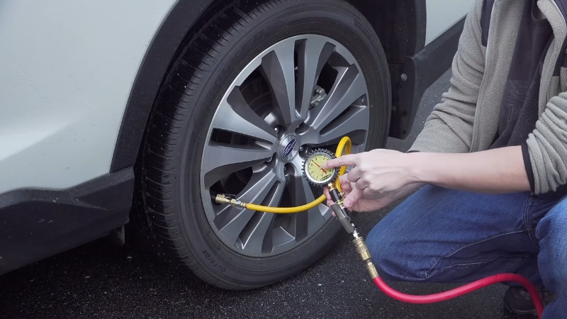 Checking tire pressure with a gauge on a cold tire to fix tire pressure light issue