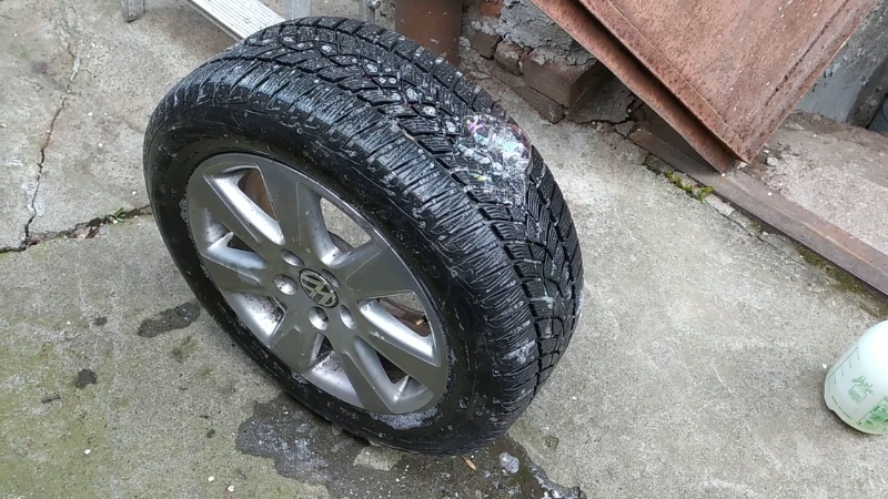 Soapy water on tire showing bubbles from a slow leak that can trigger tire pressure light