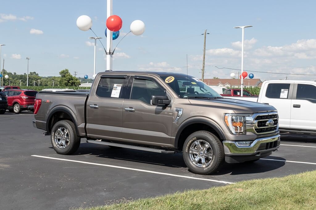 Used Ford F-150 pickup truck parked at dealership lot in daylight side view